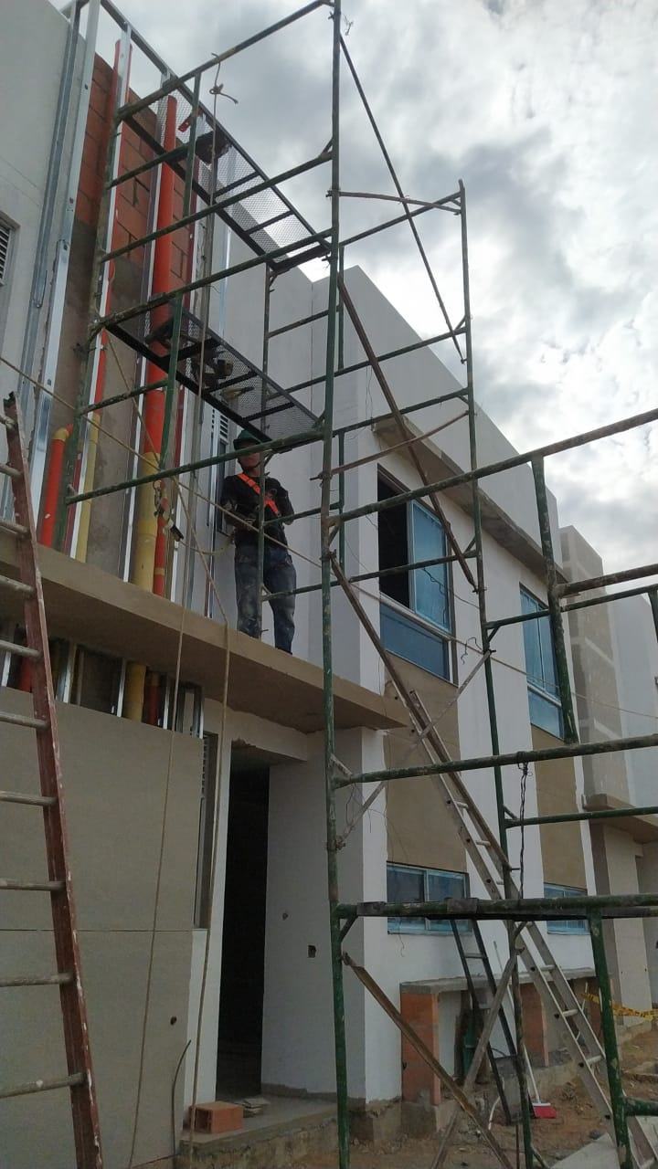 Operario trabajando sobre andamio en fachada