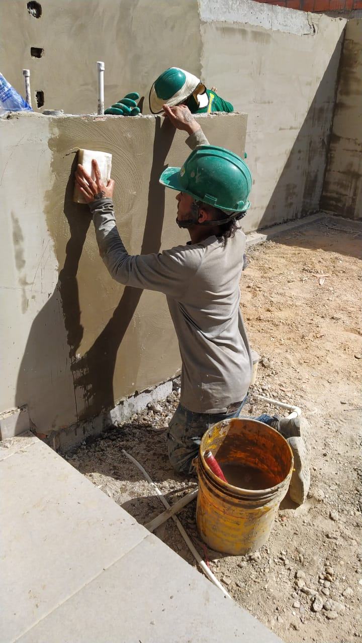Dos operarios de Milenium Color’s aplicando el acabado sobre un muro